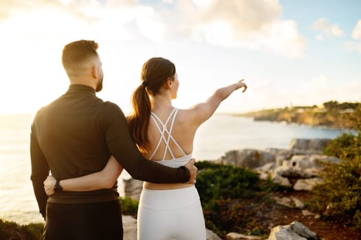 Couple in sportswear admiring the view on a coastal trail