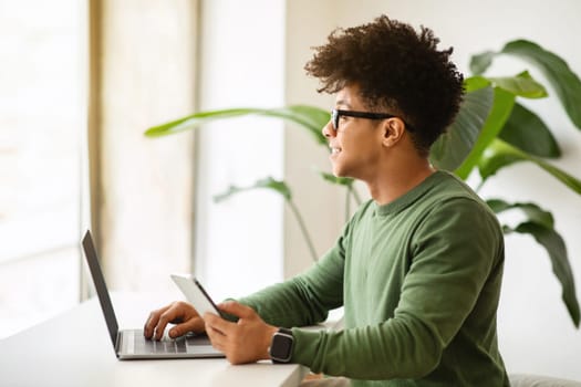 Stylish black guy startuper working online at cafe