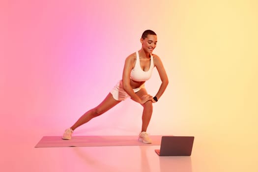 A fit woman with a buzz cut and sportswear stretches her leg muscles