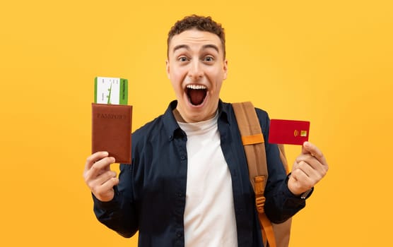 Happy guy student showing credit card and passport