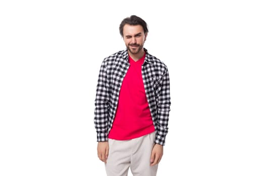 portrait of a young handsome brunette caucasian man with a beard dressed in a plaid shirt on a white background