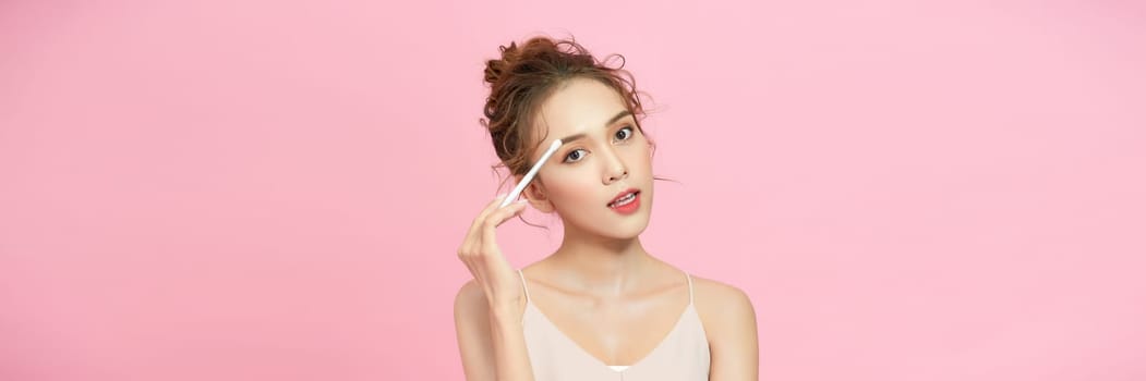 Young beautiful model with beauty face applying makeup. 