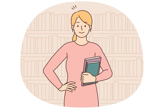Smiling woman holding books standing in library