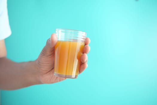 holding a glass of orange juice