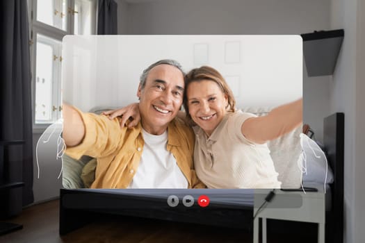 Pov screen of happy European senior couple video calling indoor