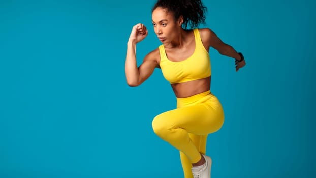 Active black sportswoman with fitness tracker running on blue background