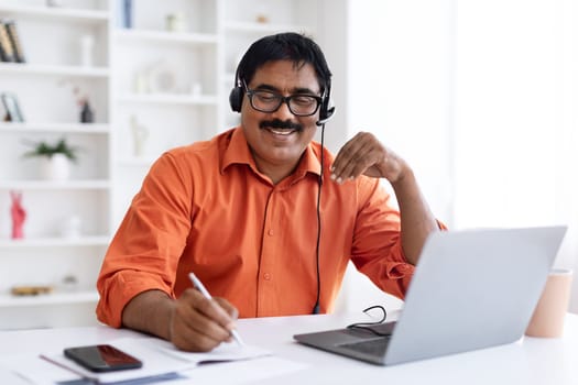 Cheerful middle aged man employee working from home office