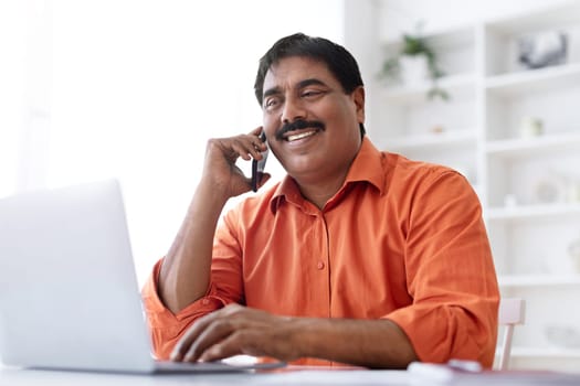 Closeup middle aged indian man working from home office
