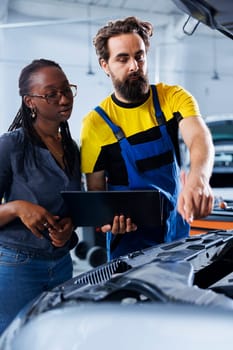 Worker informs woman of car motor costs