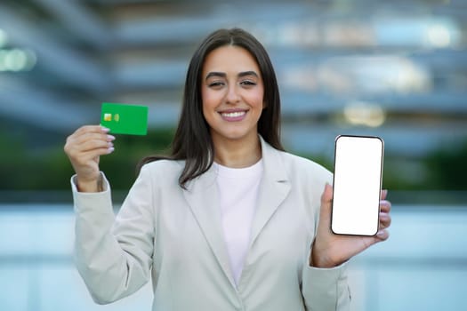 Businesswoman Showing Credit Card And Cellphone Empty Screen Outside