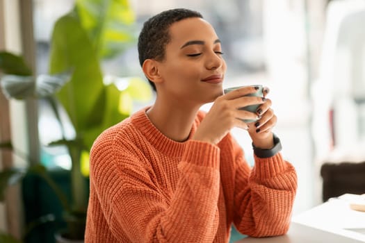 Glad calm pretty young latin woman enjoy peace and spare time, drink cup of coffee, warm moment