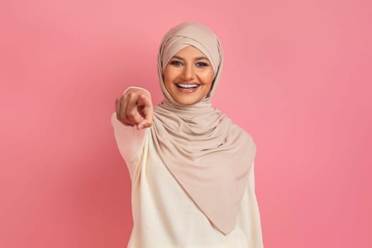 Confident arab woman in traditional hijab pointing directly at camera