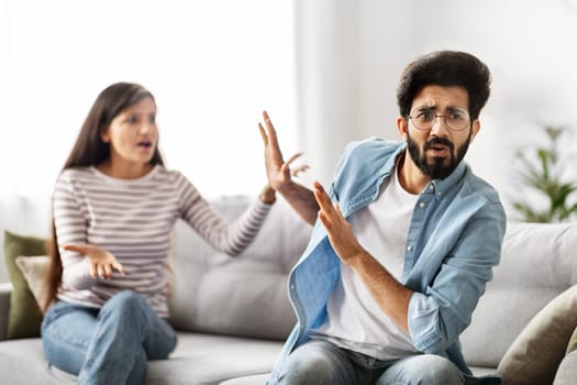 Millennial indian couple quarrelling on couch at home