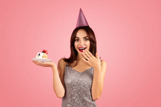Happy millennial caucasian brunette woman in party cap, dress make wish