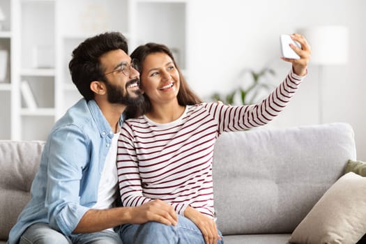 Indian man and woman taking selfie on smartphone at home