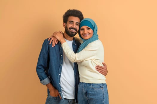 Affectionate arab muslim couple in casual clothing sharing warm embrace