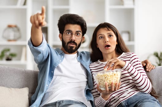 Shocked Young Indian Couple Watching Horror Movie On TV