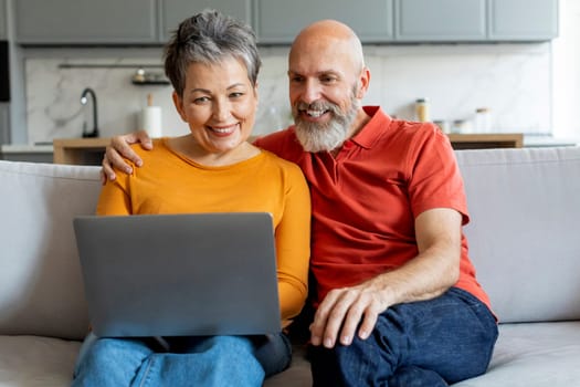 Smiling Senior Couple With Laptop Computer Booking Vacation Online