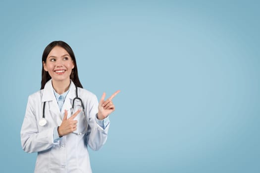 Woman doctor gesturing upwards with smile on blue background