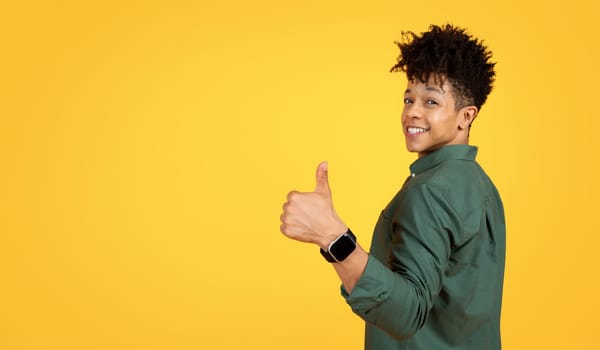 Cool young black guy showing thumb up gesture, copy space