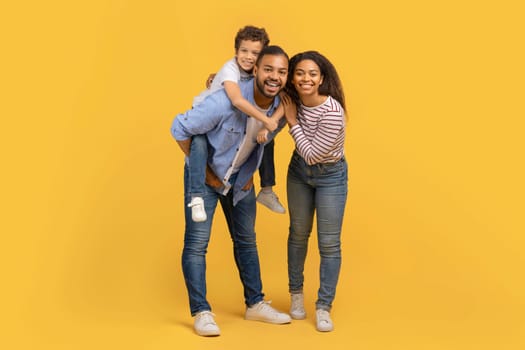 Full length shot of happy black family of three with preteen son