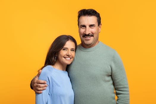 Portrait of cheerful aged european wife and husband in casual looking at camera, hugs