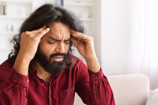 Closeup of millennial indian man have strong headache