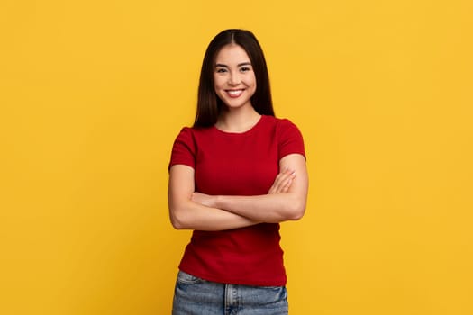 Attractive young asian woman posing on yellow background