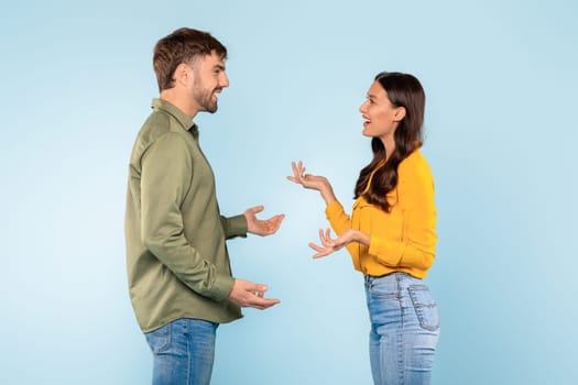 Man and woman in lively discussion on a blue background