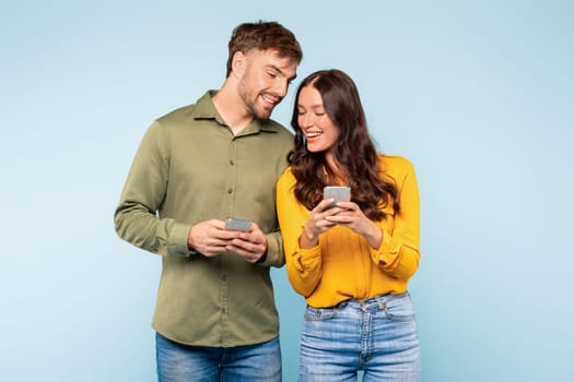 Smiling couple sharing moment over smartphones, casually connected