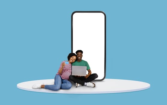 Couple with laptop and credit card by blank phone screen