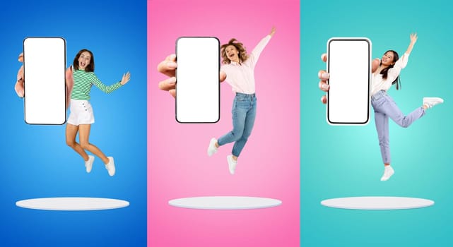 Three delighted women in casual clothes jumping high with blank-screen smartphones