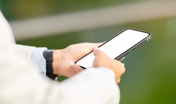 Close-up of a professional's hands using a modern smartphone, with a focus on the screen