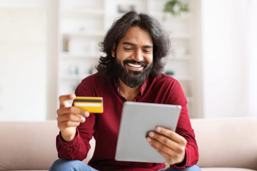 Happy indian guy enjoying newest shopping application
