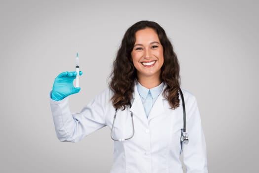 Smiling woman doctor holding syringe ready for vaccination