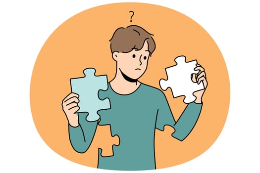 Confused man with puzzles in hands rebuild personality