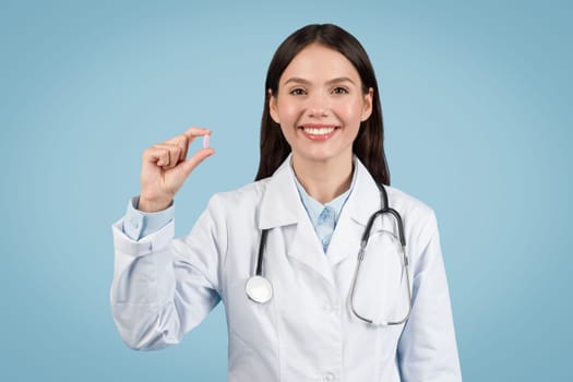 Doctor woman holding pill with confident smile