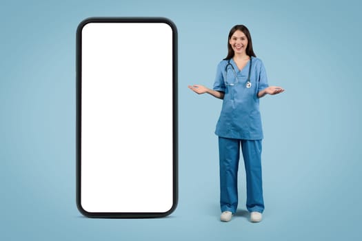 Nurse presenting mobile app on large phone, full length