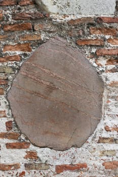 Vertical photo of a wall made of brick and large stone.