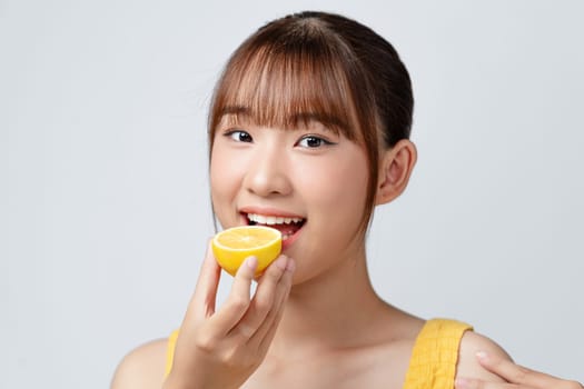 Woman eating lemon on white background, space for text