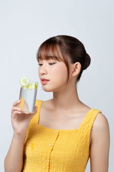 Calm youthful lady refreshing herself with lemon water