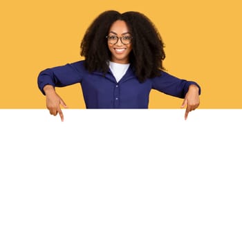 Black woman with big smile pointing to blank space for text