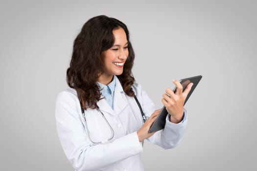 Doctor woman using tablet with friendly expression
