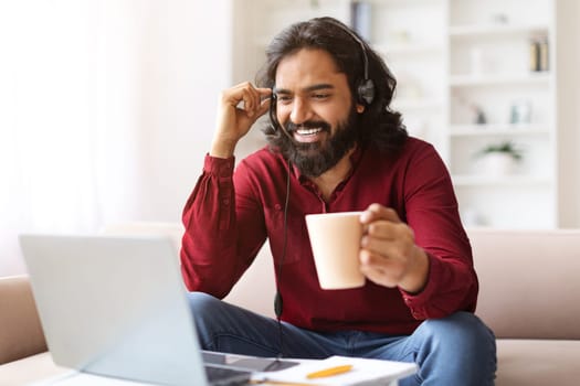 Smiling millennial eastern guy studying online from home