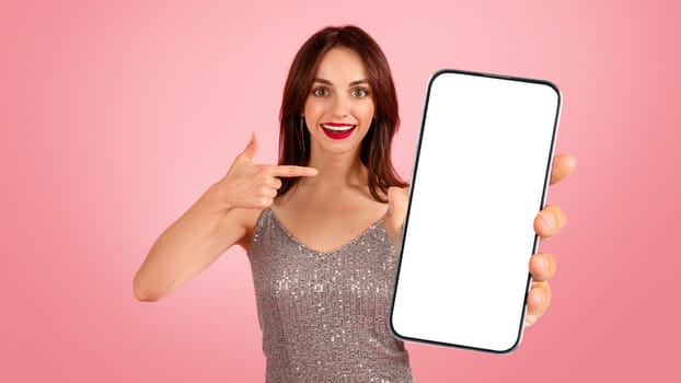 A surprised woman with brown hair and red lipstick excitedly points to a blank smartphone screen