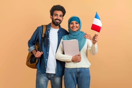 International Education. Arabic Student Couple With Backpacks Holding Flag Of France