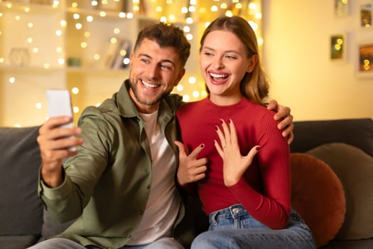 Couple taking selfie during romantic proposal at home