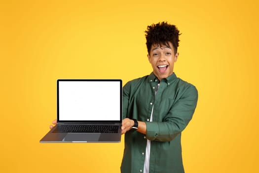 Cool african american young man holding laptop