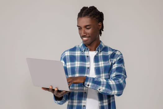 Freelance Work. Portrait Of Smiling African American Guy Using Laptop