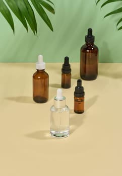 Glass bottles for cosmetics, oils with a pipette on a beige background